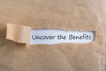 Uncover The Benefits text on brown envelope. Word Uncover The Benefits on torn paper.