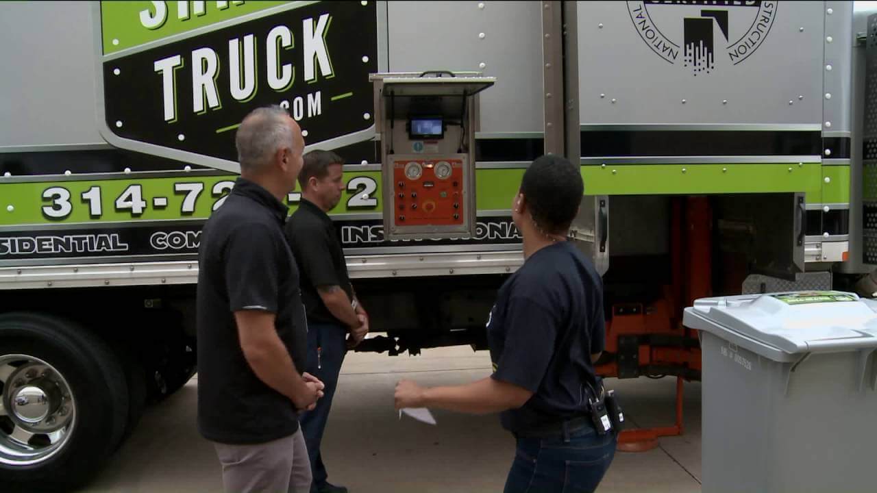 Image of paper shredding professionals in front of a mobile paper shredding truck