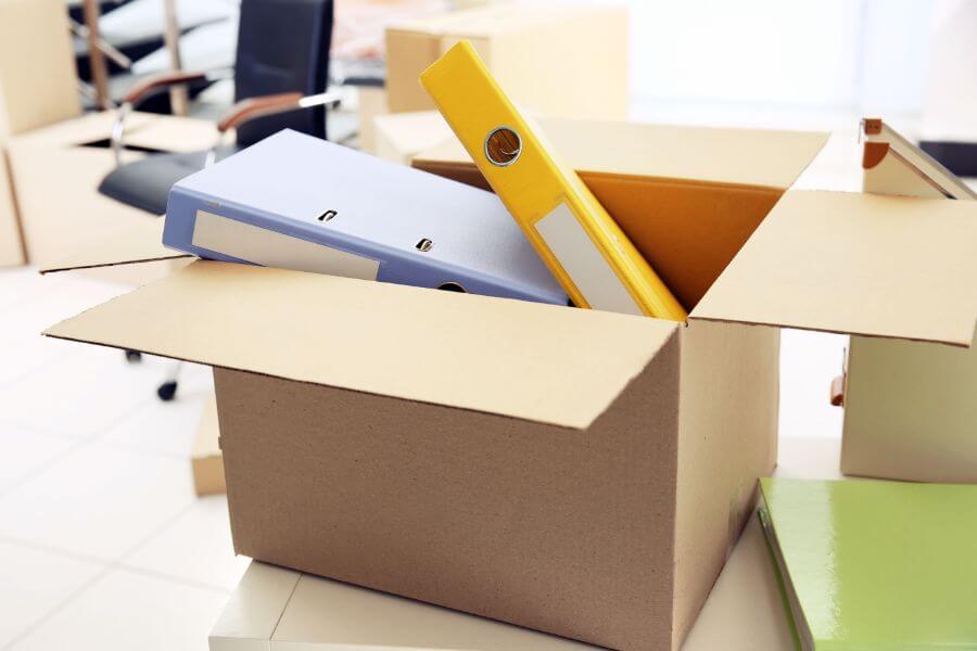 Image of binders with paper in a cardboard box